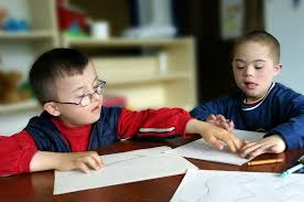 two young students collaborating on schoolwork at a table